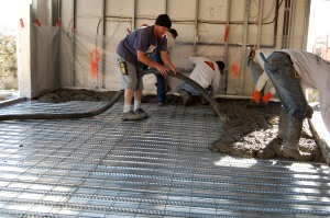 Wire mesh sits atop steel B decking as concrete is pumped.